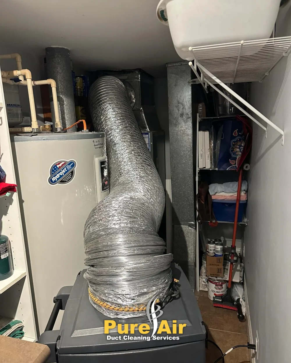 HEPA-certified air duct cleaning machine connected to a furnace in a basement