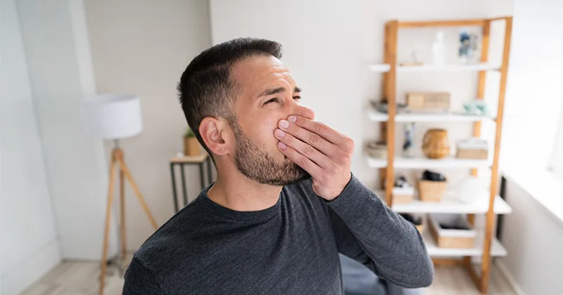 Man covering his nose because of a bad smell at home